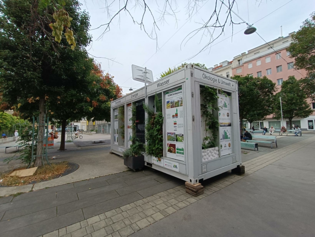 MUGLI, der mobile Ausstellungsraum von GRÜNSTATTGRAU präsentiert bis Ende September 2023 Bauwerksbegrünung am Wiener Volkertmarkt. Komm vorbei!